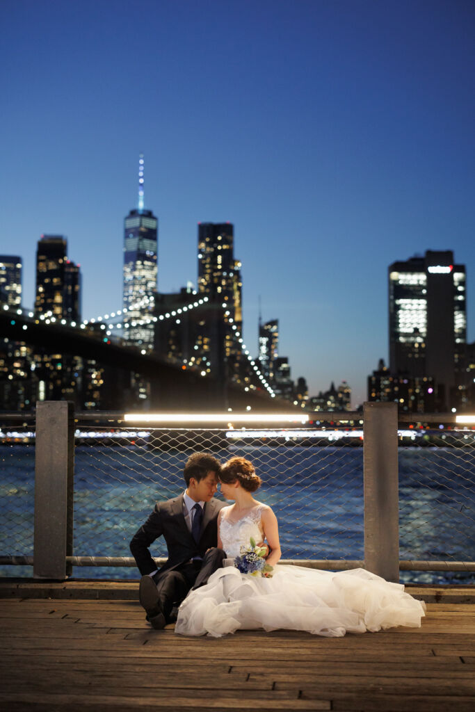 ニューヨーク前撮り/ウェディングフォト/日が暮れたマンハッタンの夜景を背景に腰を下ろして。