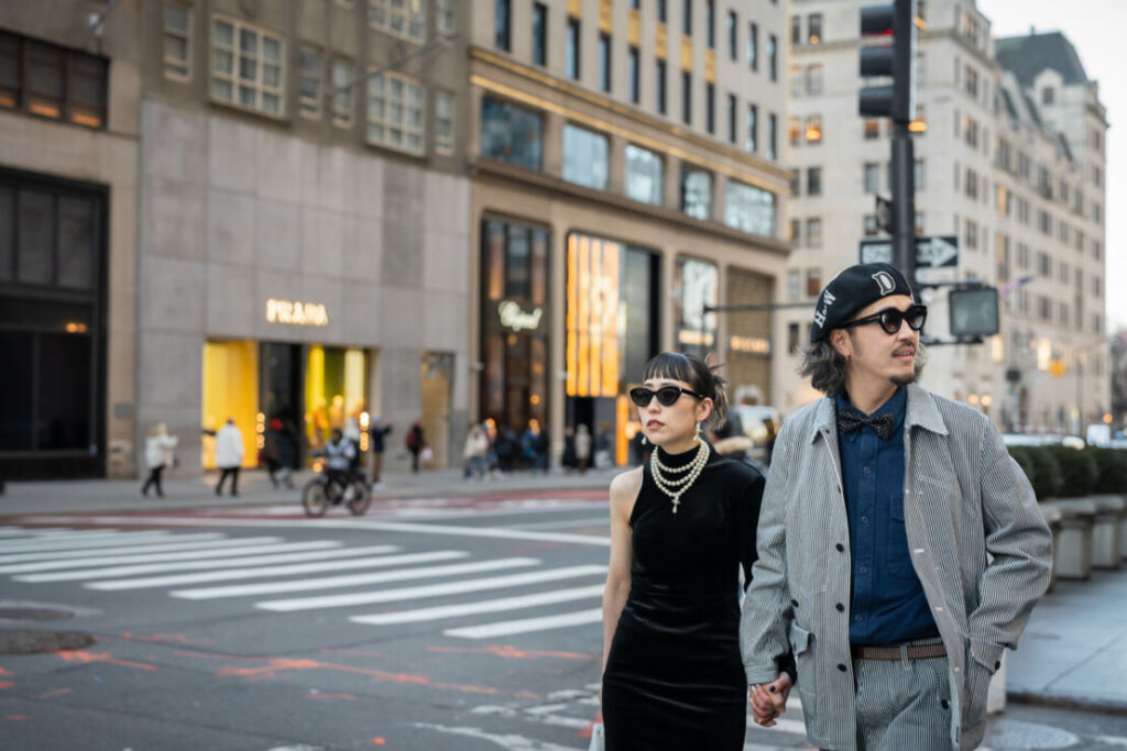 ニューヨークの５番街の横断歩道をわたるサングラスをかけた男女
