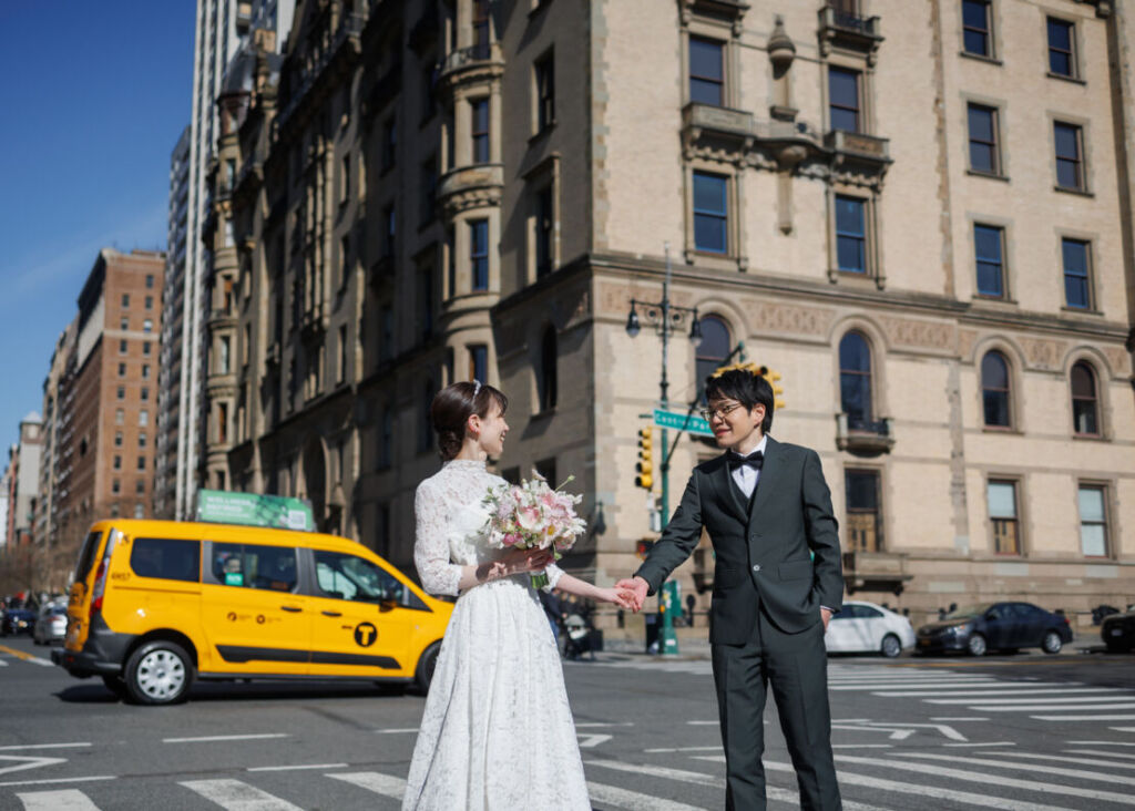 アメリカニューヨークの前撮り/フォトウェディング/ダコタハウス前に立つ花嫁花婿。