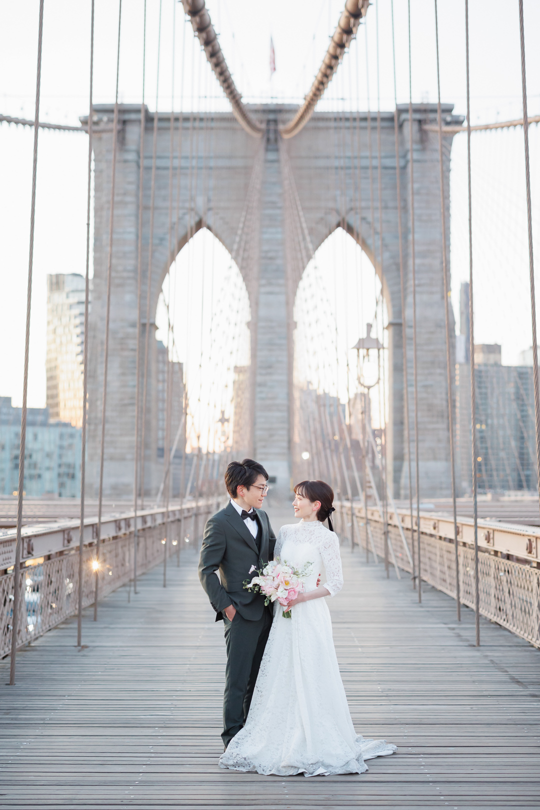 アメリカニューヨークの前撮り/フォトウェディング/ブルックリンブリッジの真ん中で見つめ合う花嫁と花婿。