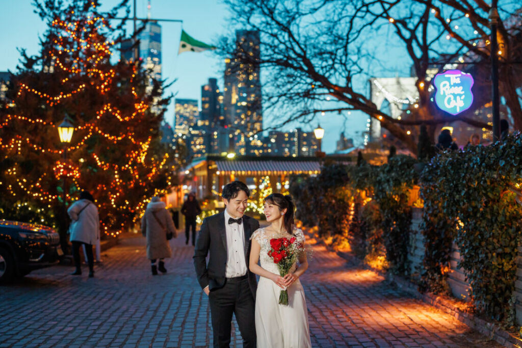 アメリカニューヨークの前撮り/フォトウェディング/リバーカフェの前を歩く花嫁と花婿。
