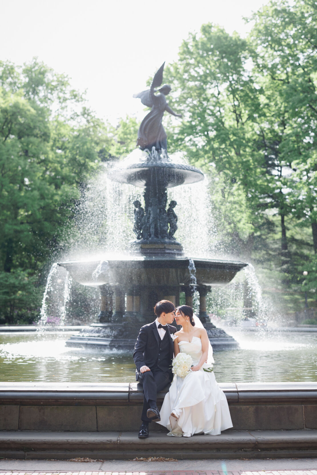 ニューヨークの前撮り/ウェディングフォト|ベセスダの噴水で腰かける花婿と花嫁。