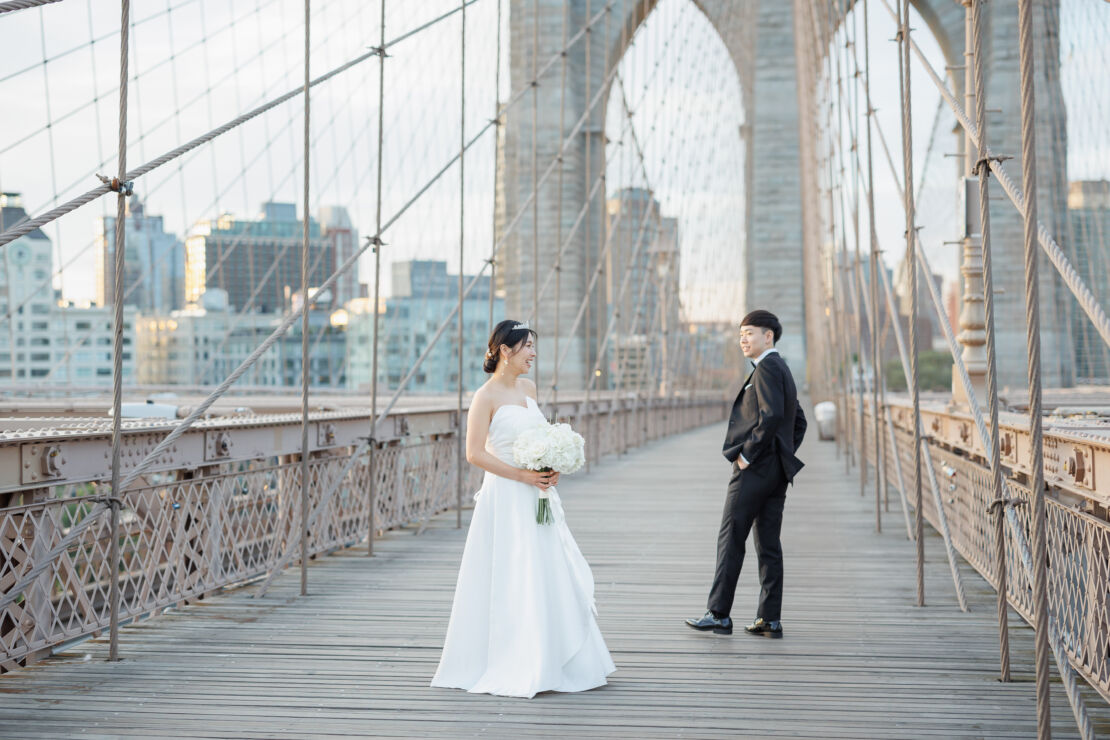 ニューヨークの前撮り/ウェディングフォト|ブルックリンブリッジに立つカップル。