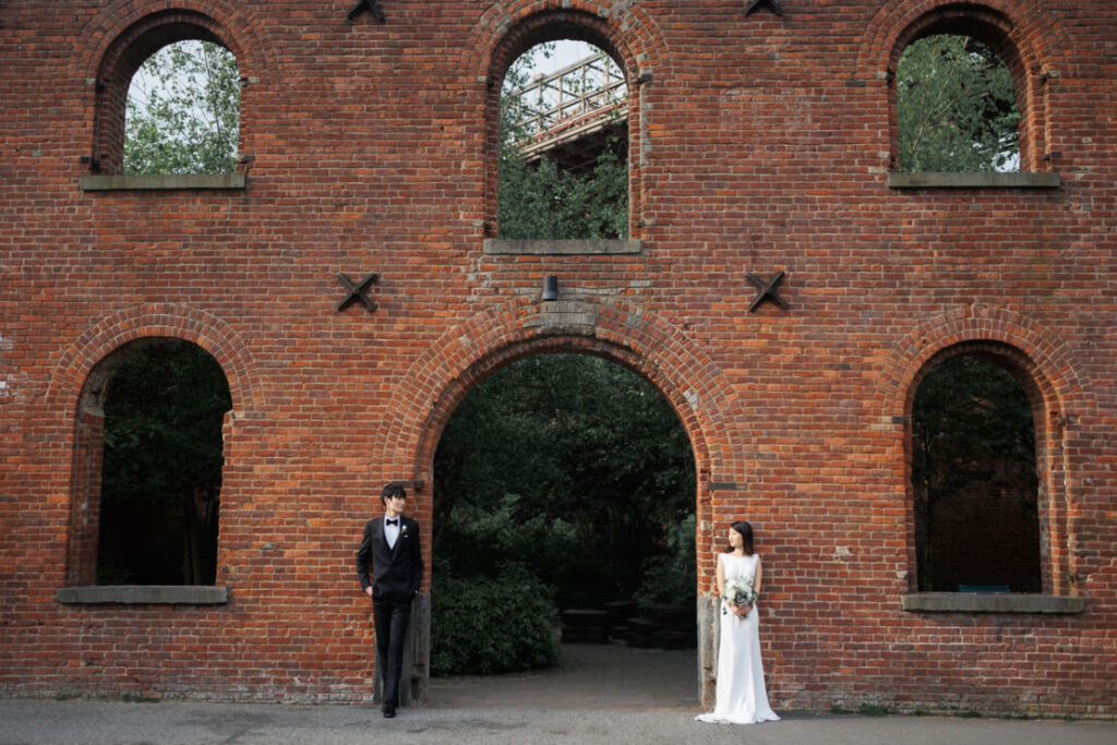 ニューヨークの前撮り/フォトウェディング|max family gardenの壁に立つ花嫁と花婿。