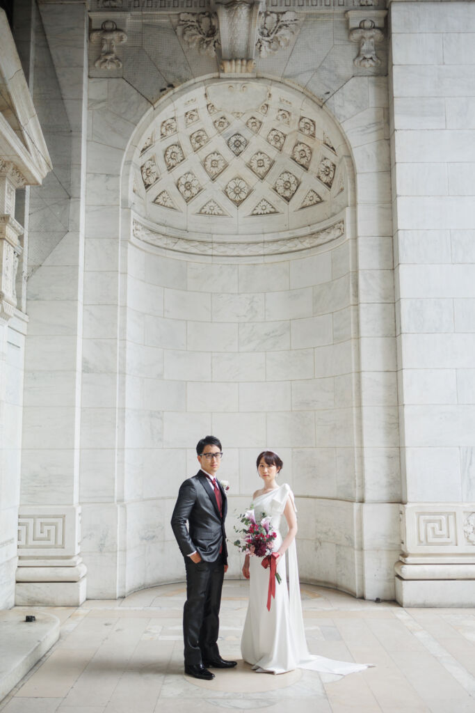 ニューヨーク前撮り/ウェディングフォト|NYPLの大理石の壁の前に立つ花嫁と花婿。
