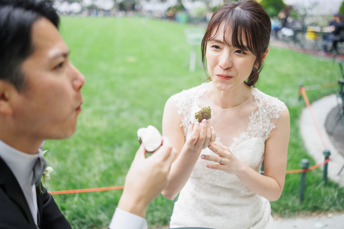 ニューヨークの前撮り/フォトウェディング|ブライアントパークでおにぎりを食べる花嫁と花婿。