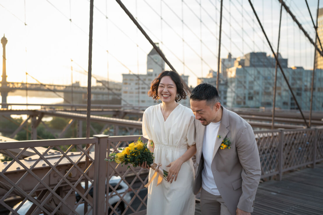 ニューヨークのフォトウェディング/前撮り|ブルックリンブリッジで談笑する花嫁と花婿。