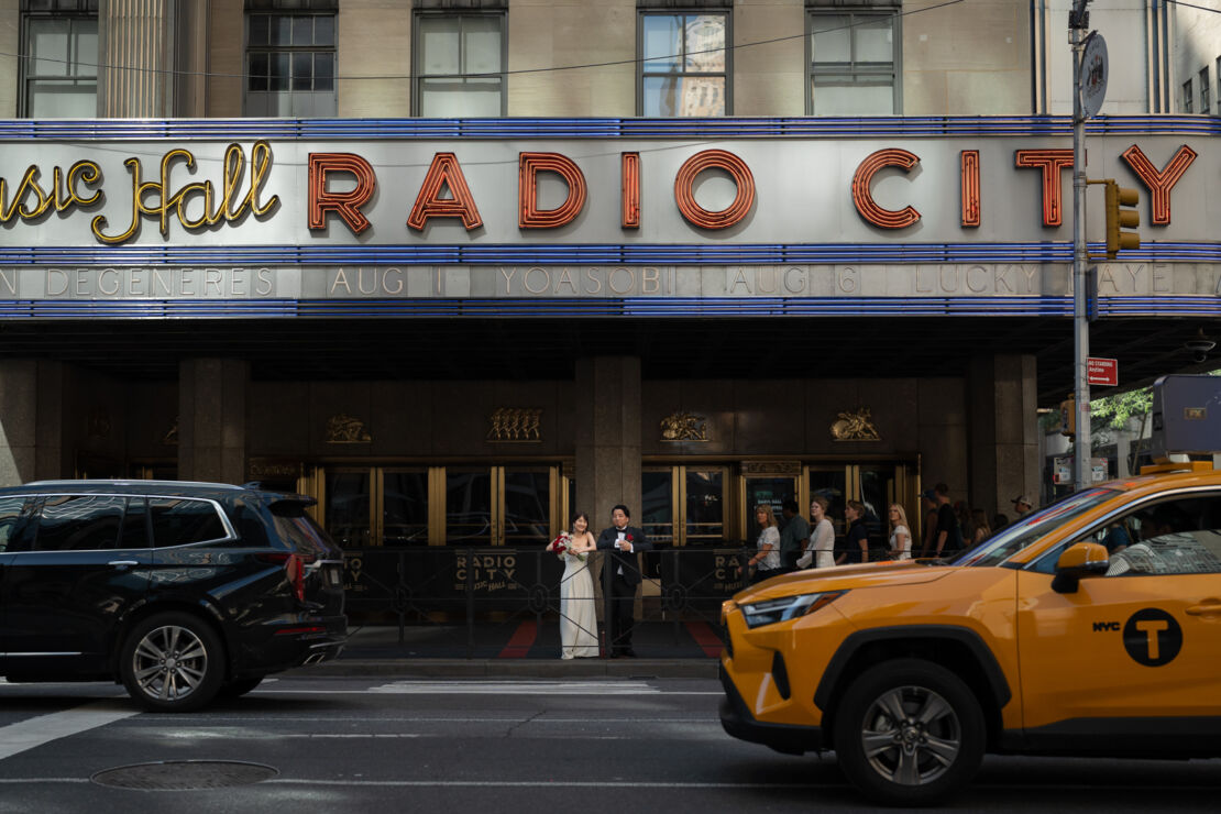 ニューヨークの前撮り/フォトウェディング|RADIO CITY MUSIC HALL前の花嫁と花婿。