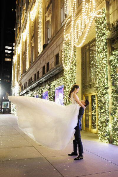 ニューヨークの前撮り/フォトウェディング|ホリデーショーウィンドウを背景に抱っこショット。
