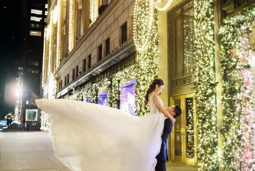 ニューヨークの前撮り/フォトウェディング|ホリデーショーウィンドウを背景に抱っこショット。