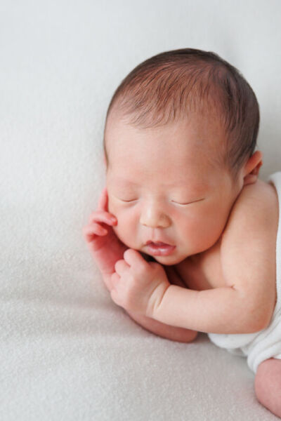 ニューヨークでニューボーンフォト:サイドポーズで眠る新生児。