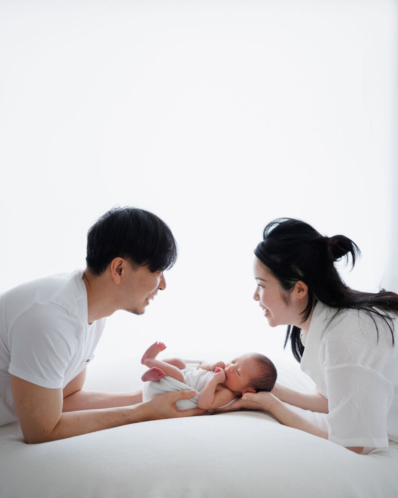 ニューヨークでニューボーンフォト/新生児を真ん中にして、見つめ合うパパとママ。