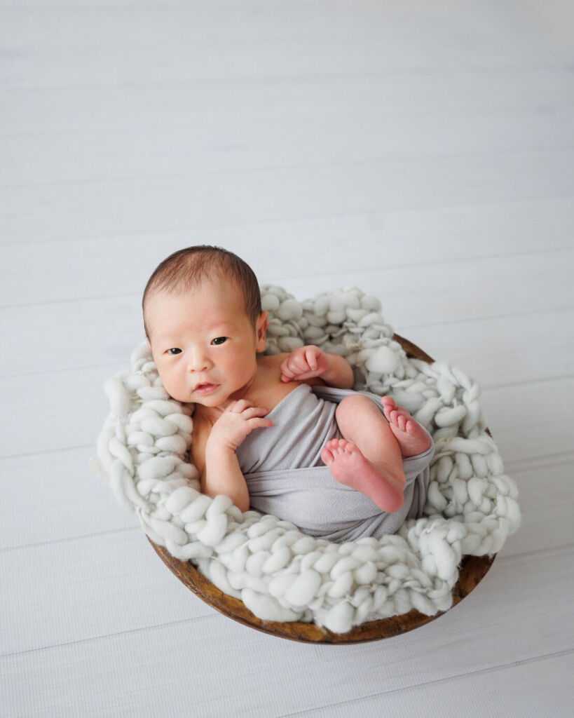 ニューヨークでニューボーンフォト/バスケットの中から澄んだ瞳で見つめる新生児。