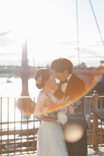 ニューヨークでフォトウェディング|前撮り/ブルックリンブリッジの朝日を浴びる花嫁と花婿。