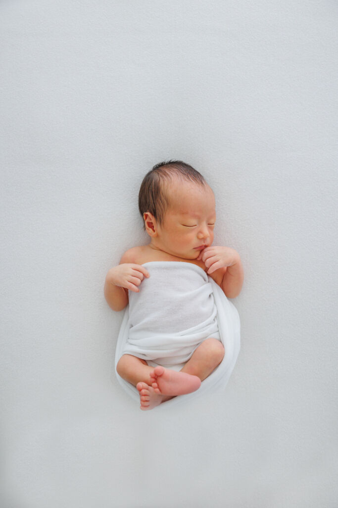 ニューヨークのニューボーンフォト/丸くなって眠る新生児。