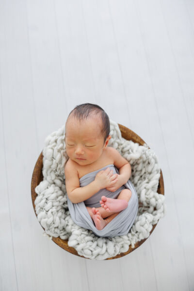 ニューヨークのニューボーンフォト/バスケットに入って眠るベビー。