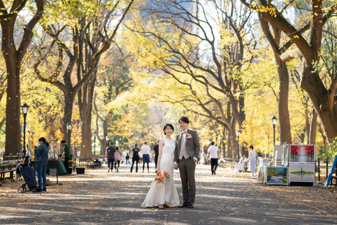 ニューヨークのウェディングフォト|前撮り/紅葉真っただ中のザ・モールに立つ花嫁と花婿。