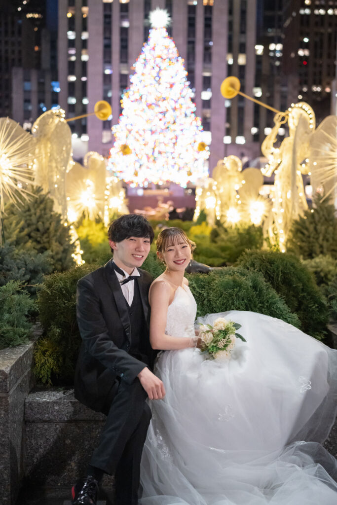 ニューヨークの前撮り|フォトウェディング/ロックフェラーセンター前に腰かける花嫁と花婿。