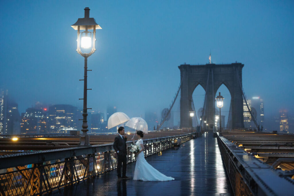 ニューヨークでウェディングフォト/霧に包まれたブルックリンブリッジに立つ花嫁と花婿。