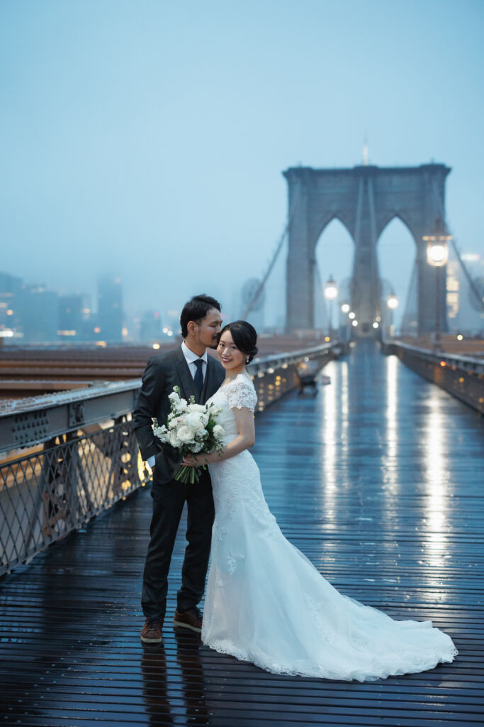 ニューヨークでウェディングフォト/ブルックリンブリッジのボードウォークが雨に濡れて趣深い。