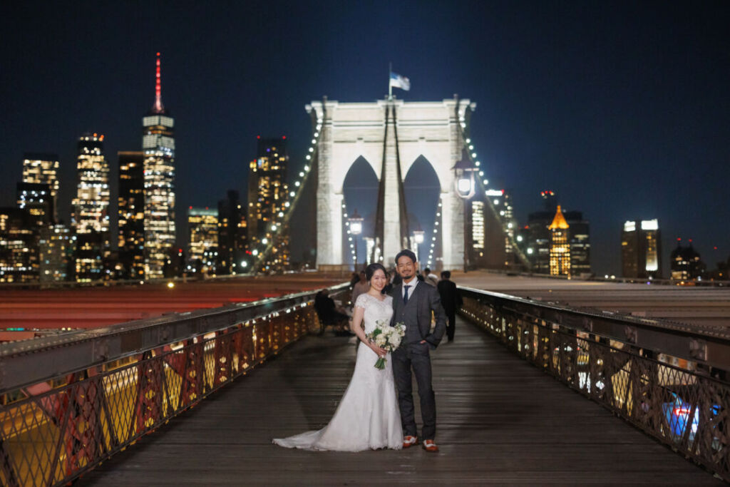 ニューヨークでウェディングフォト/輝くニューヨークの夜空にほほ笑む花嫁と花婿。