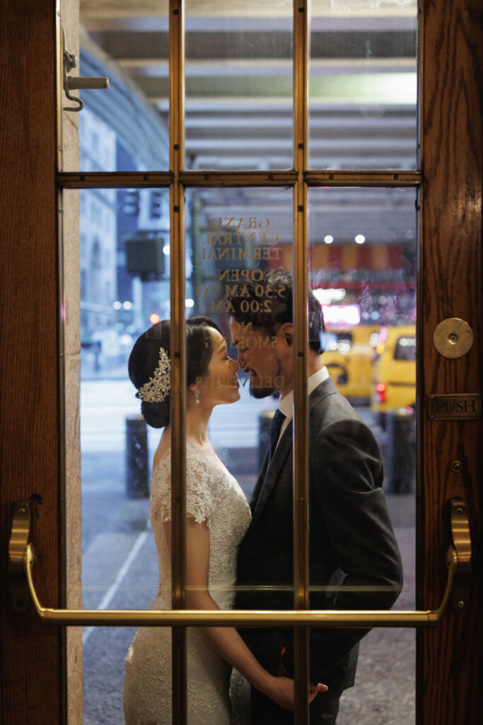 ニューヨークでウェディングフォト/グランドセントラル駅の出入り口の前に立つ花嫁と花婿。