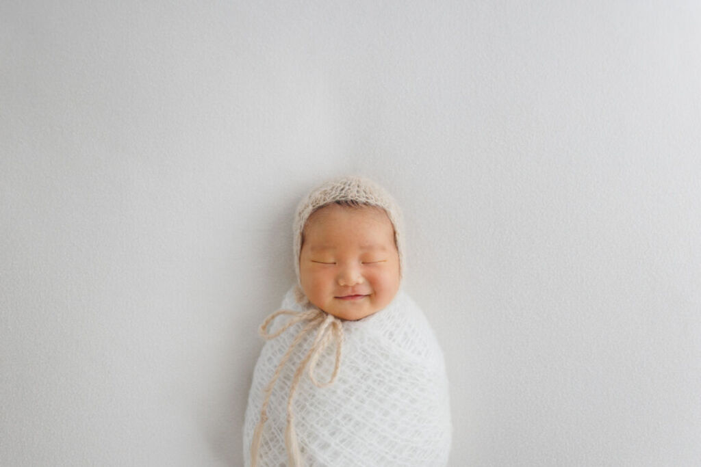 ニューヨークでニューボーンフォト/みのむしポーズの新生児微笑。