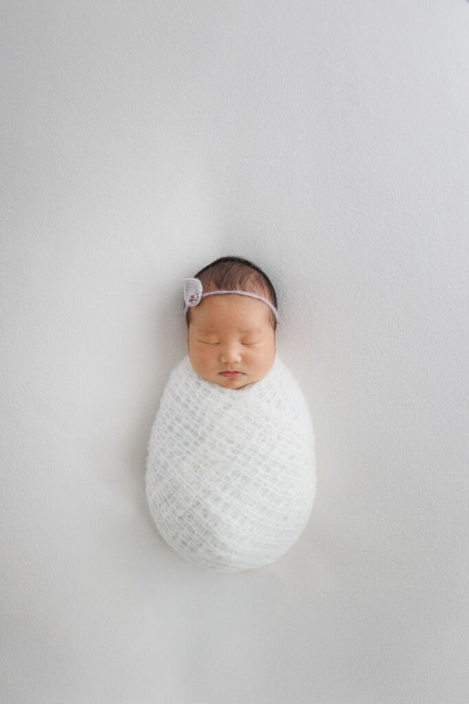 ニューヨークでニューボーンフォト/みのむしポーズの新生児、すやすやと寝息が聞こえてきそう。