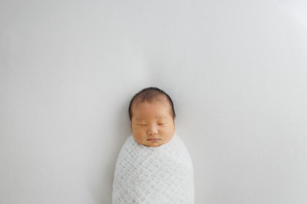 ニューヨークでニューボーンフォト/みのむしポーズの新生児。