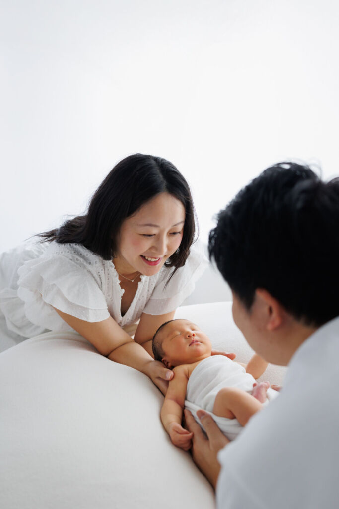 ニューヨークでニューボーンフォト/パパとママがベビーを見つめる。