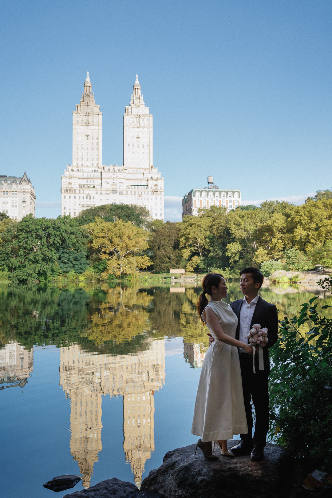 ニューヨークの前撮りウェディングフォト/ザ・レイクのほとりに立つ花嫁と花婿。
