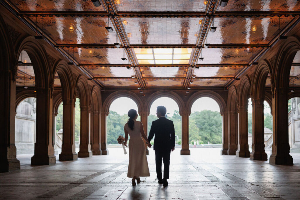 ニューヨークの前撮りウェディングフォト/ベセスダテラスを歩くカップルの後ろ姿。