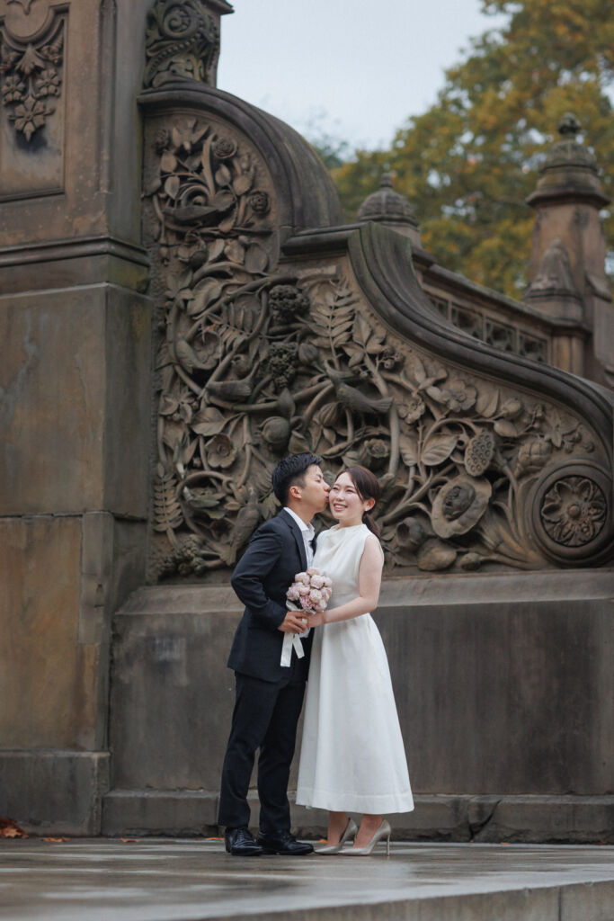 ニューヨークの前撮りウェディングフォト/ベセスダテラスの大階段の彫刻を背景に。