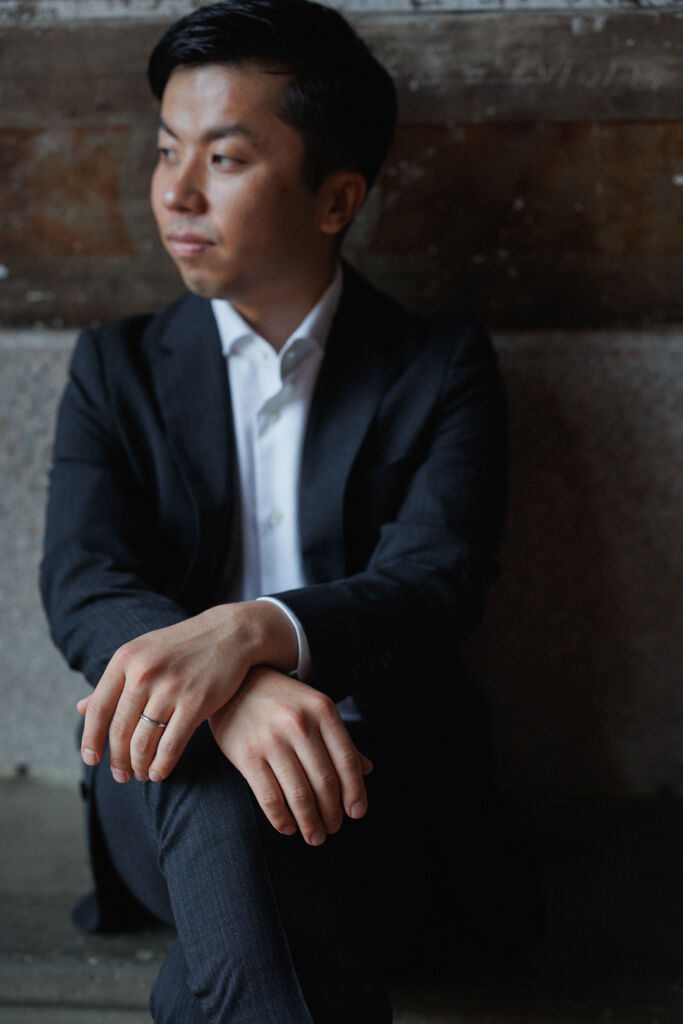 ニューヨークの前撮りウェディングフォト/ベセスダテラスの壁画前に座る花婿さま。