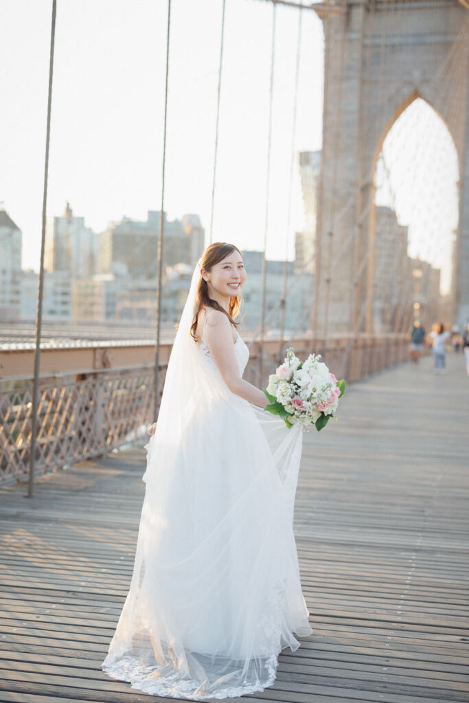 ニューヨークのウェディングフォト|前撮り/ブルックリンブリッジの朝日を浴びて透けるウェディングベール。