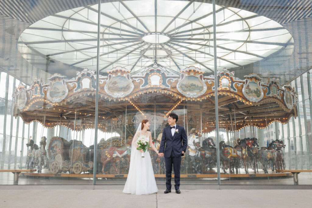 ニューヨークのウェディングフォト|前撮り/ジェーンズカルーセルの前に立つ花嫁と花婿。