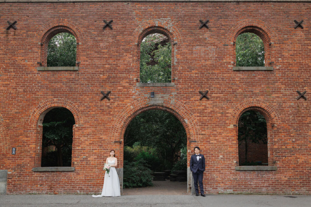 ニューヨークのウェディングフォト|前撮り/マックスファミリーガーデンの入り口に立つ花嫁と花婿。