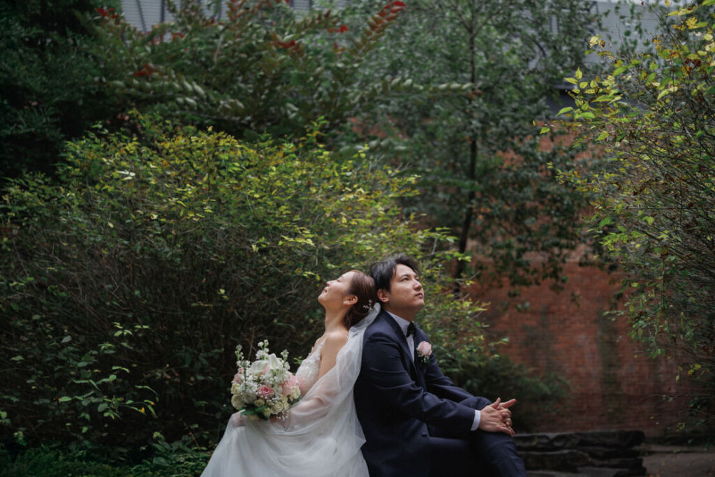 ニューヨークのウェディングフォト|前撮り/背中にもたれ合う花嫁と花婿。