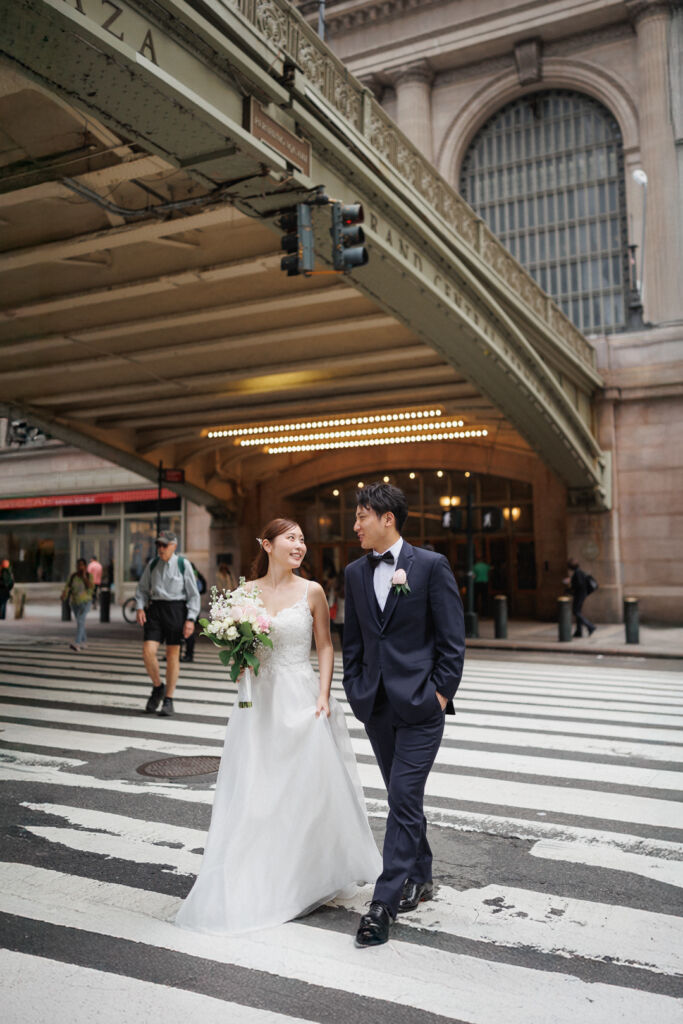 ニューヨークのウェディングフォト|前撮り/グランドセントラル駅の構外を歩く花嫁と花婿。