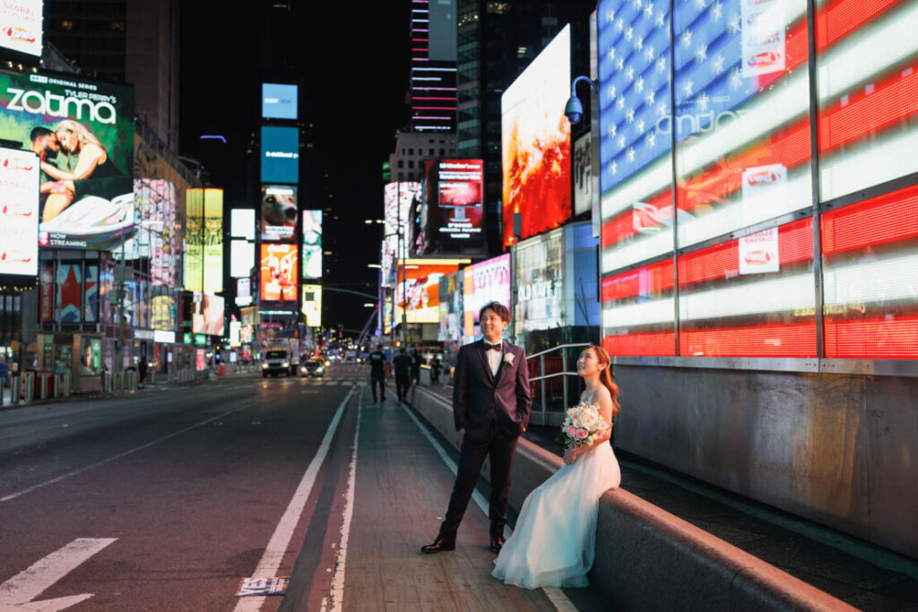 ニューヨークのウェディングフォト|前撮り/タイムズスクエアのアメリカ国旗ネオンの前でウェディングフォト。