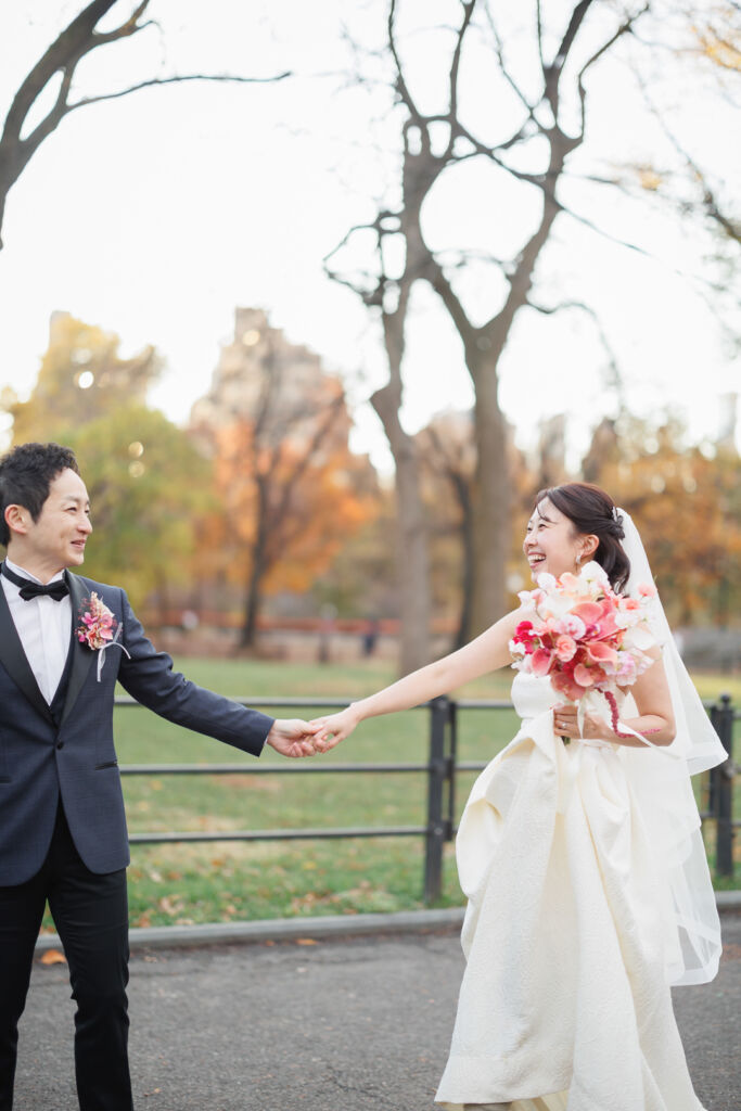 ニューヨークの前撮り|ウェディングフォト/ザ・モールで楽しそうに手をつなぐ花嫁と花婿。