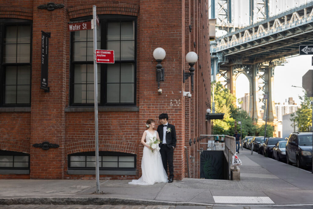 ニューヨークの前撮り|ウェディングフォト/レンガ造りの建物の前で会話する花嫁と花婿。
