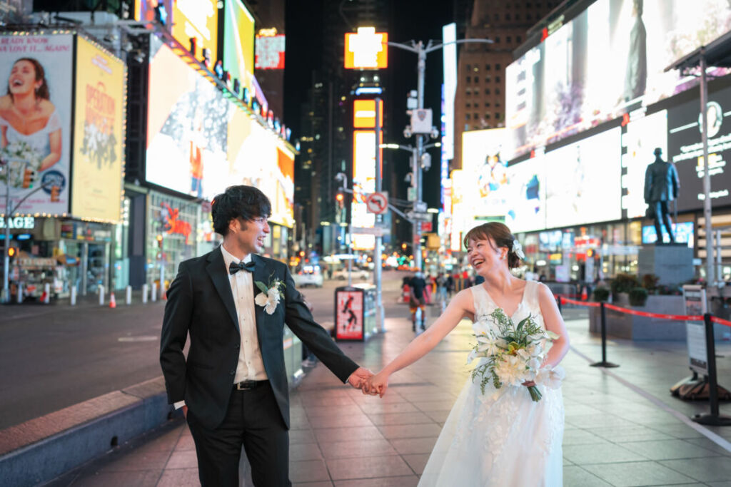 ニューヨークの前撮り|ウェディングフォト/タイムズスクエアで手をつなぐカップル。