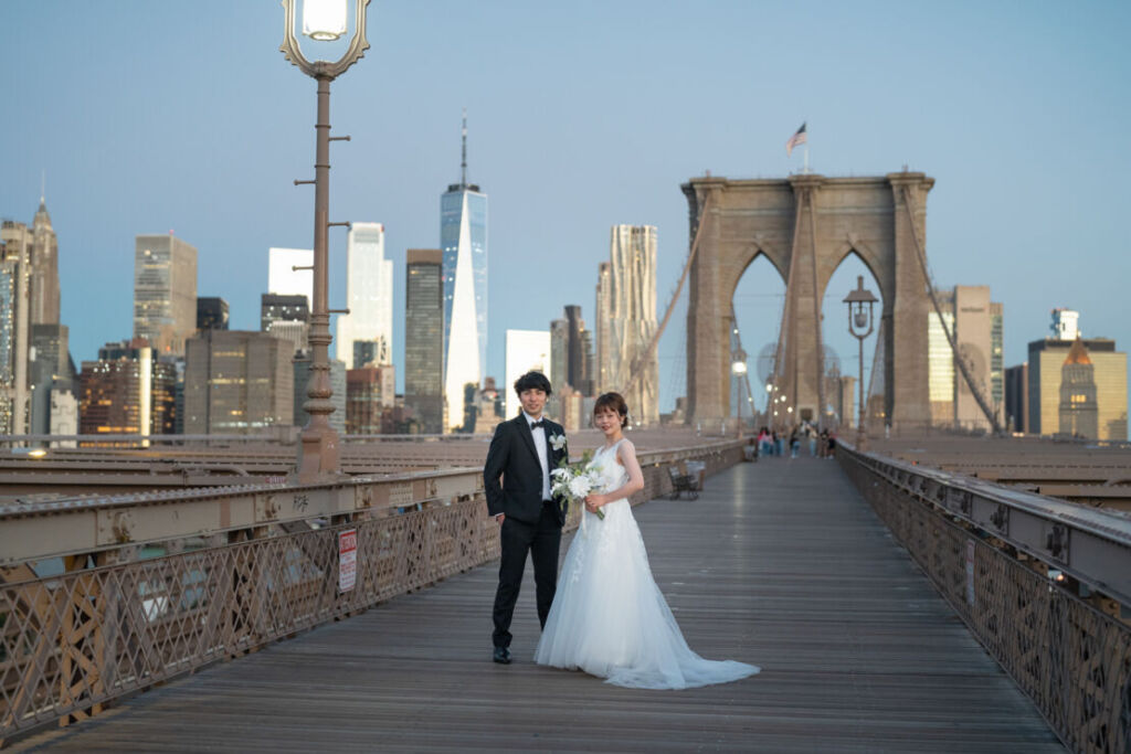 ニューヨークの前撮り|ウェディングフォト/ブルックリン橋に立つ花嫁と花婿。