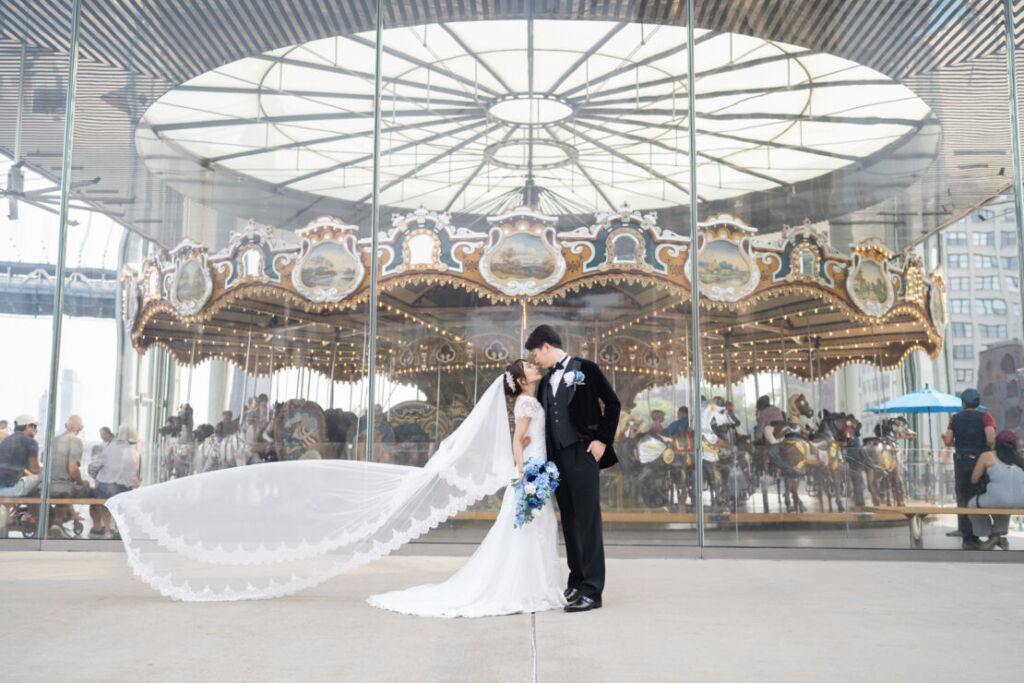 ニューヨークの前撮り|ウェディングフォト/ジェーンズカルーセルの前で、ポージングが美しい花嫁と花婿。