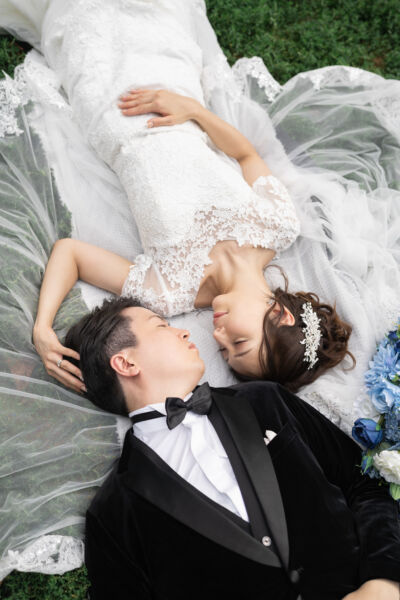 ニューヨークの前撮り|ウェディングフォト/芝生に寝転がる花嫁と花婿。
