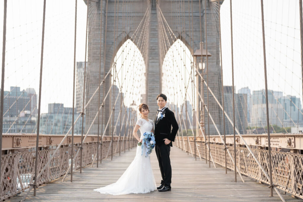 ニューヨークの前撮り|ウェディングフォト/ブルックリン橋に立つ花嫁と花婿。