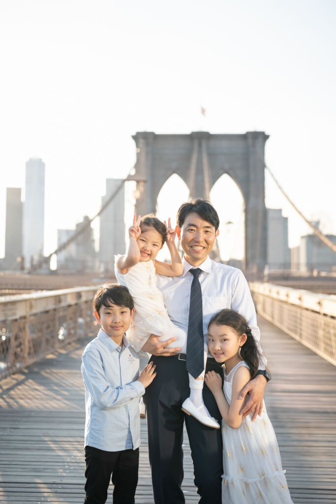 ニューヨークのファミリーフォト/ブルックリン橋に立つパパと３人の子供たち。