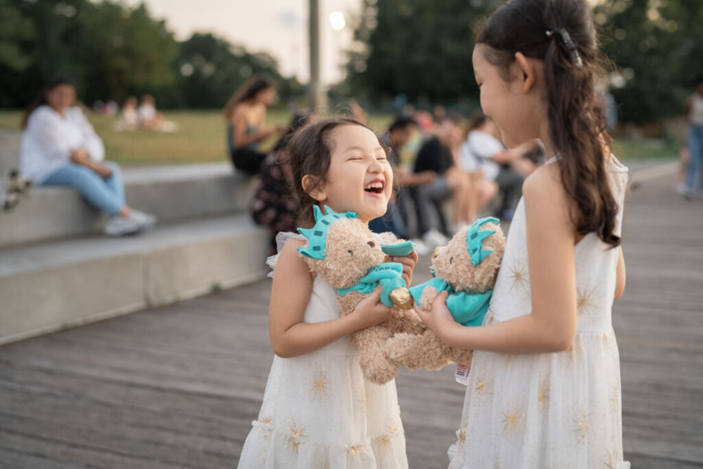 ニューヨークのファミリーフォト/自由の女神モチーフのテディベアで遊ぶ姉妹。