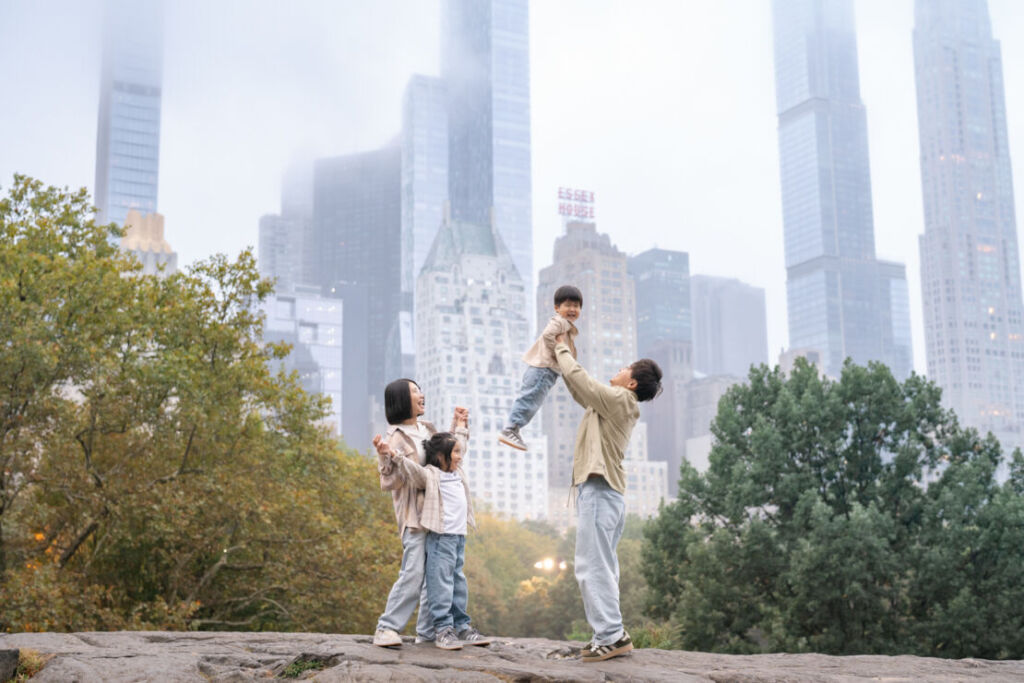 ニューヨークでファミリーフォト/ラットロックの上にご家族４人が経っている。